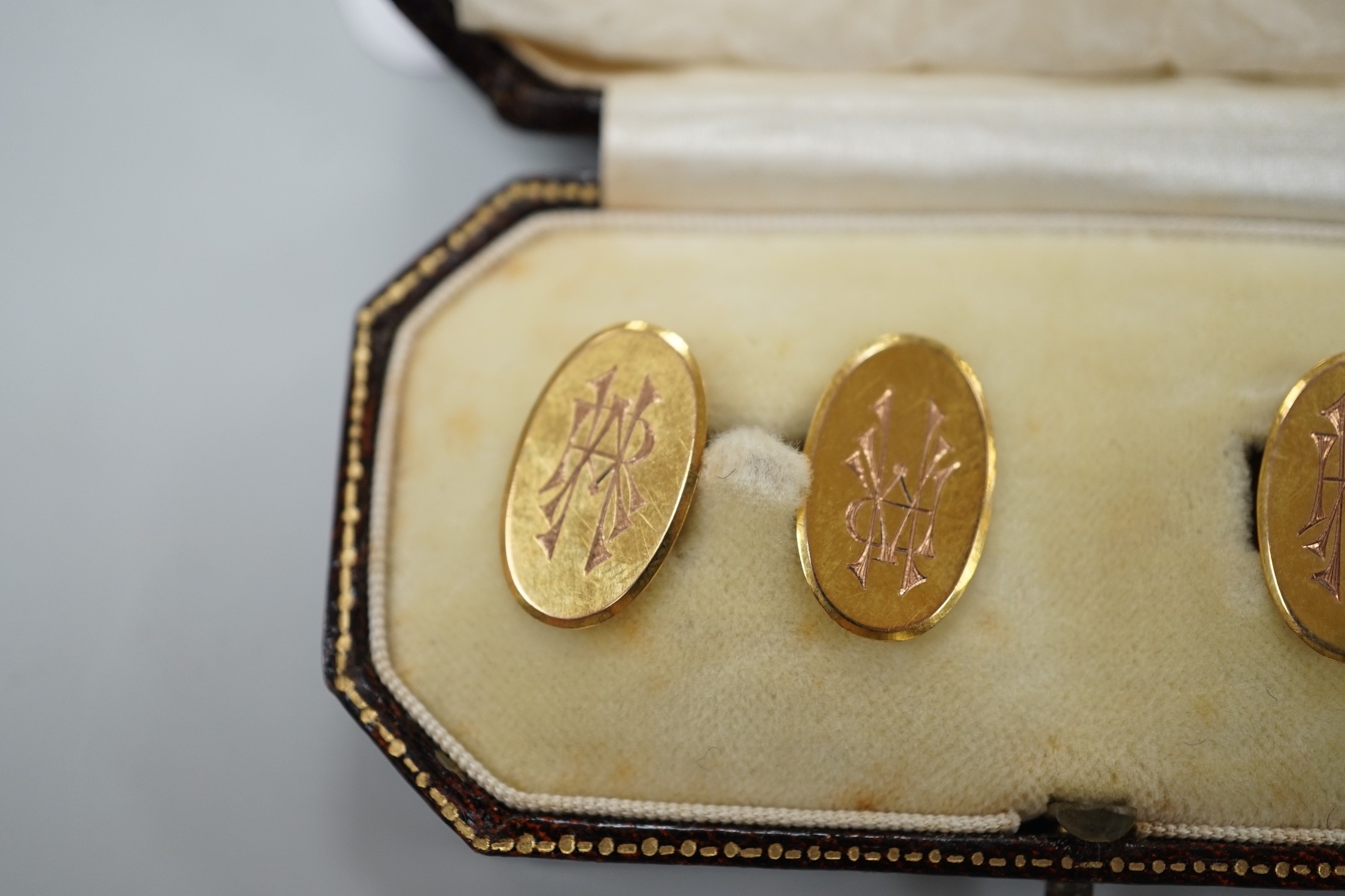 A pair of George V 9ct. gold oval cuff links, with engraved monograms, cased, 4.3 grams.